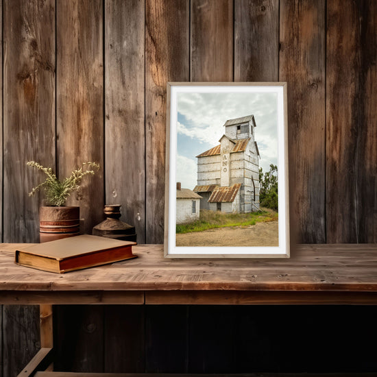 A photography print depicting an old Kansas grain elevator, its wooden surface weathered and a tin roof reflecting the history of America's agricultural heartland.