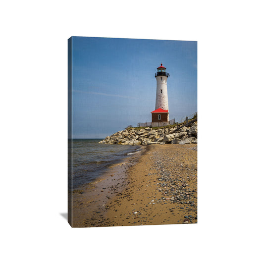 A high-resolution photography canvas print of Crisp Point Lighthouse with its white tower and red-roofed lantern room, against a blue sky beside a rocky lake shore.