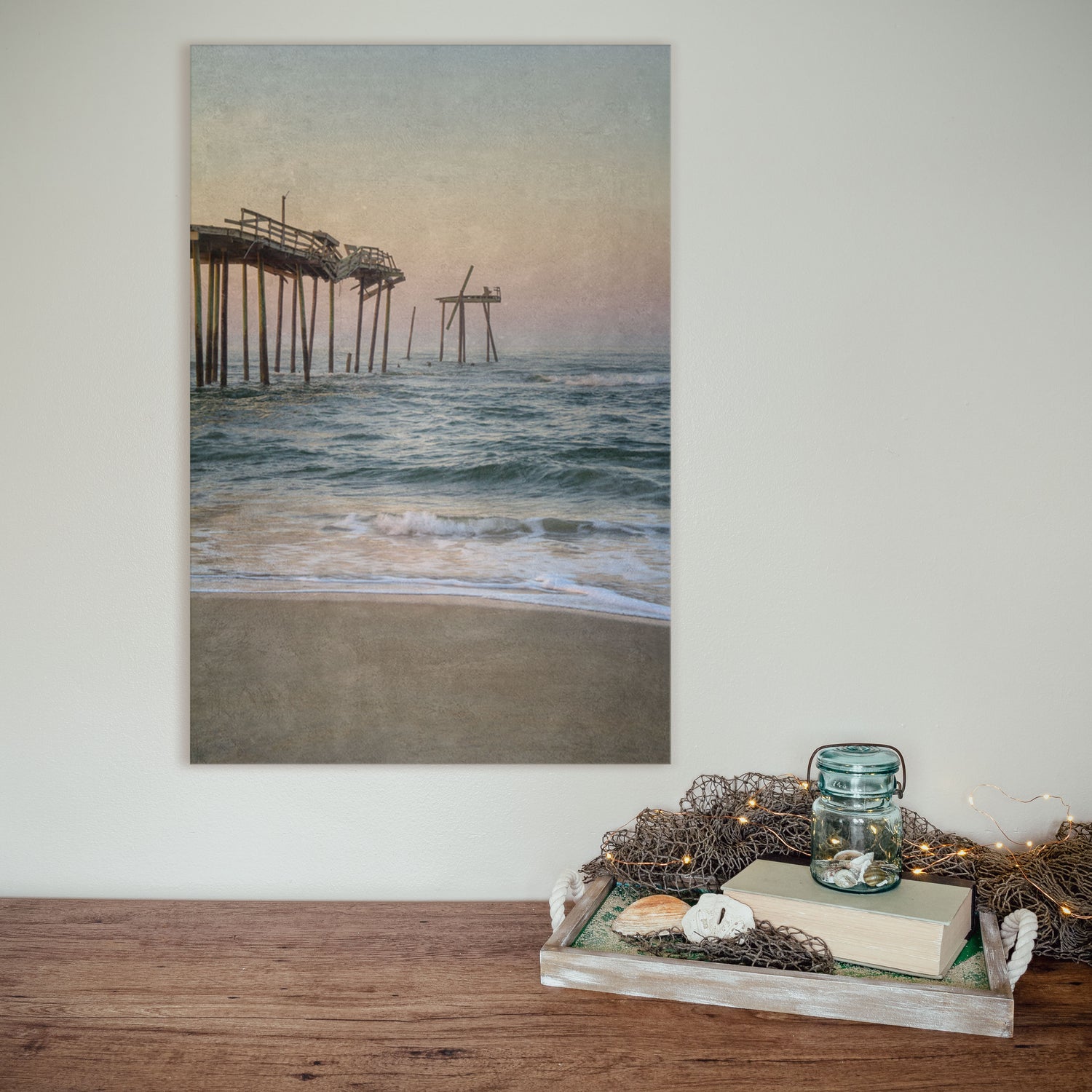 A vintage-inspired Frisco Pier Vintage canvas wall art print showcasing the iconic landmark in the Outer Banks of North Carolina. The canvas features a textured, weathered aesthetic, adding a touch of nostalgia and charm to any space. Soft pastel colors depict a serene sunset, creating a tranquil ambiance.