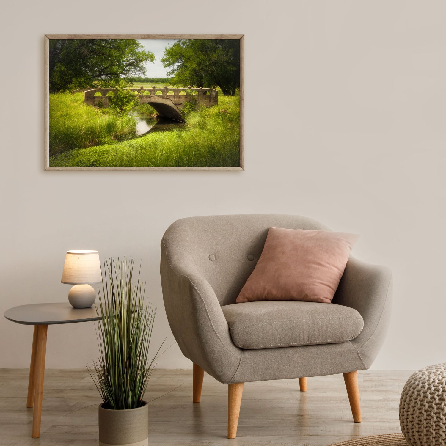 Wall art capturing the rustic charm of a countryside bridge, set against the backdrop of flourishing plants and soft natural light.