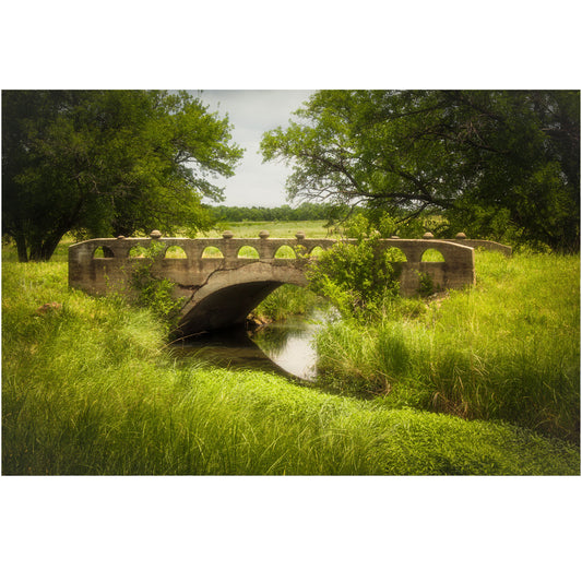 Detailed view of an aged stone bridge amidst vibrant green foliage, embodying a serene landscape in high-quality photography print form.