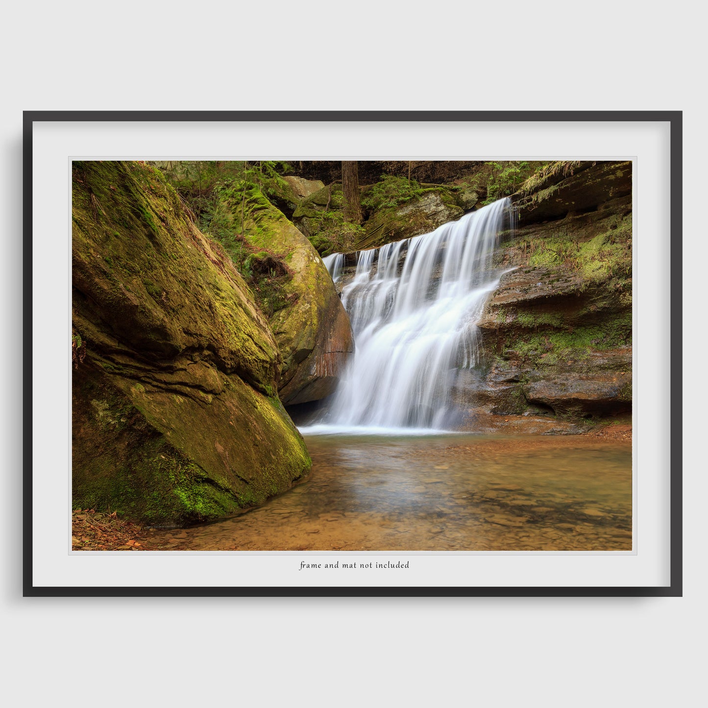 Image displaying a waterfall wall art print within a thin black frame and white mat, meant to inspire potential display options. The actual product is the print only; the frame and mat are not included with purchase.