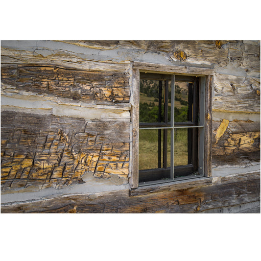 Image of a time-worn window on a rustic log cabin wall, capturing the warm hues of twilight—a testament to the tranquil beauty of simpler times.