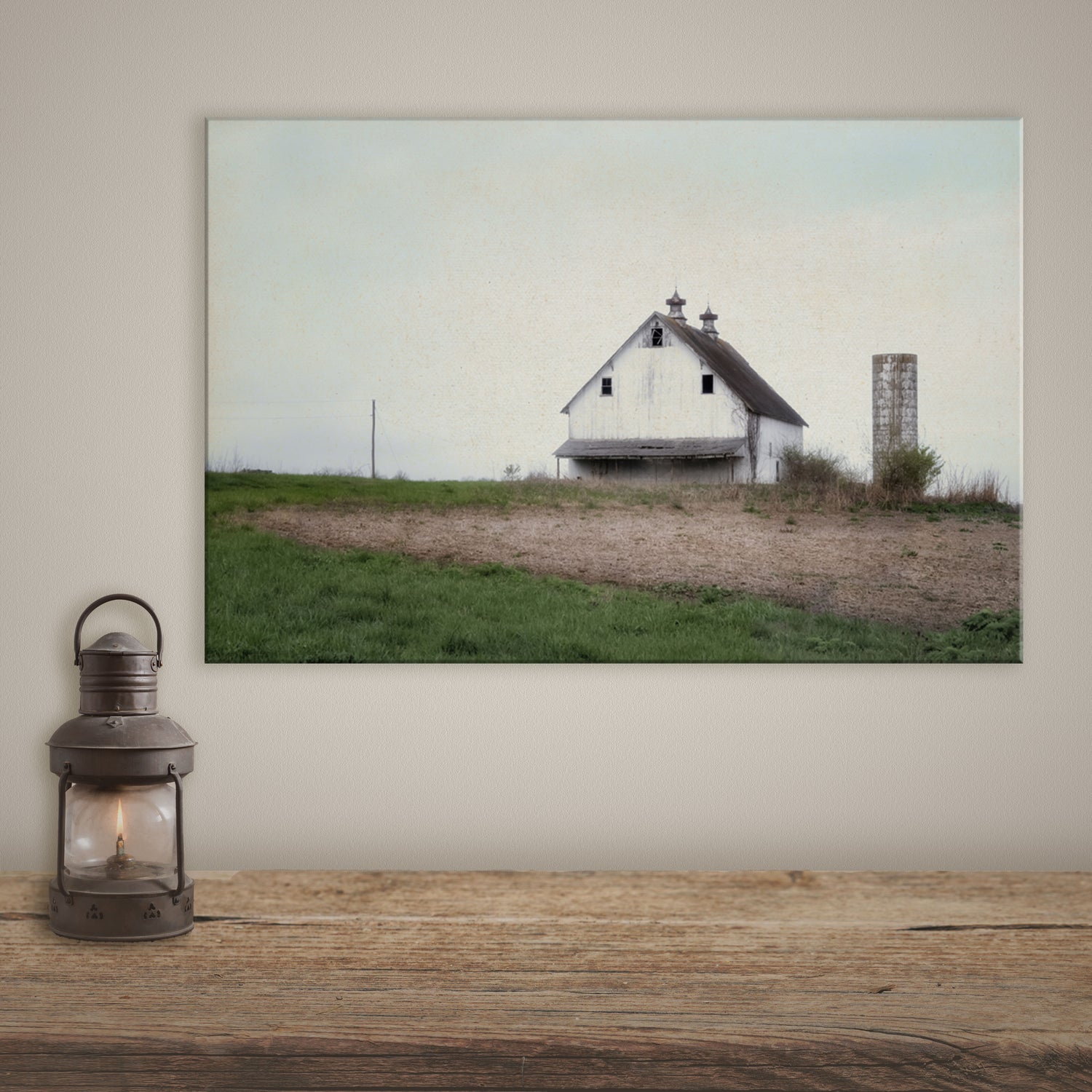 Canvas print featuring an old white barn, perfect for farmhouse style wall decor, set in a rustic and tranquil countryside setting.