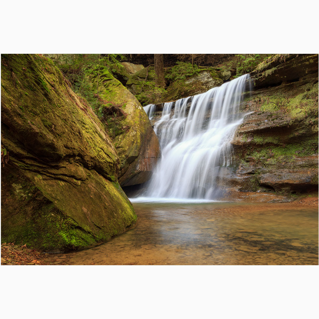 Nature photography wall art featuring a serene waterfall nestled in the lush landscape of Hocking Hills, Ohio, with water gently cascading over moss-covered rocks."